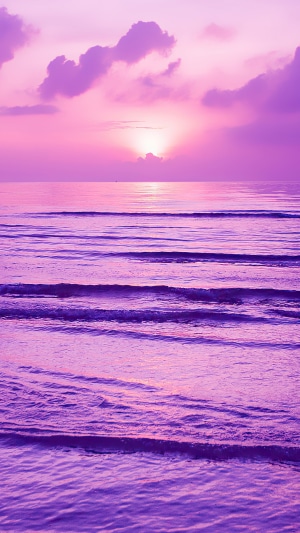 Purple sunset over the ocean with waves