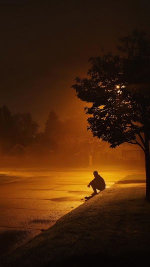 Man sitting by the road at night