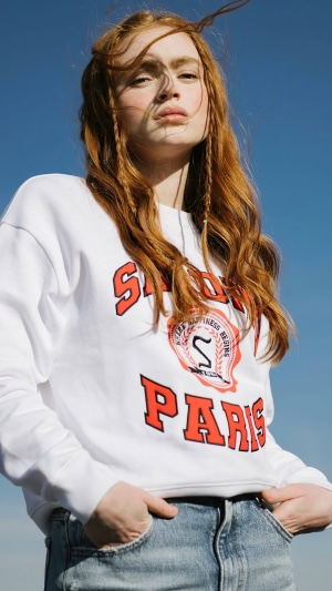 Sadie Sink wearing a white sweatshirt and jeans