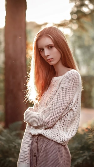 Redhead girl in a white sweater and skirt