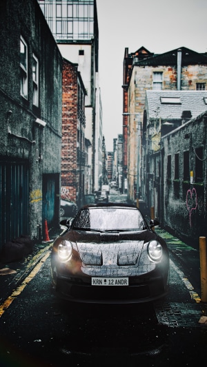 Porsche 911 in a wet alleyway