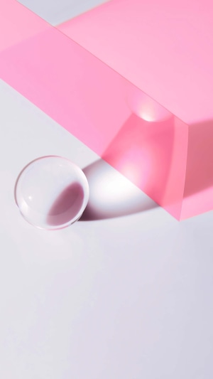 Abstract composition with pink translucent shapes and glass sphere