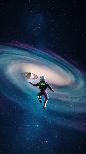 Astronaut holding Saturn in a galaxy