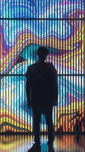 Silhouette of a person against a colorful digital art background