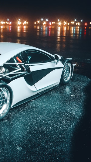 White McLaren 570S on wet road at night