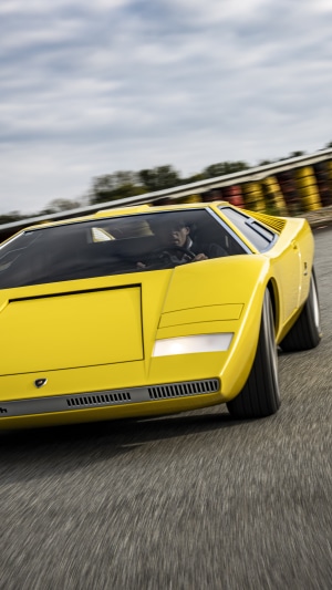 Yellow Lamborghini Countach driving on a track