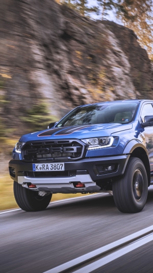 Blue Ford Ranger Raptor driving on a road