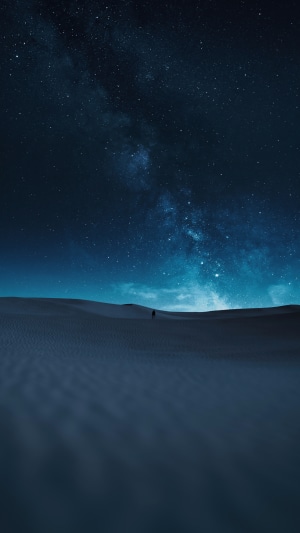 Man walking in desert under starry sky