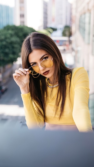 Victoria Justice wearing yellow top and sunglasses