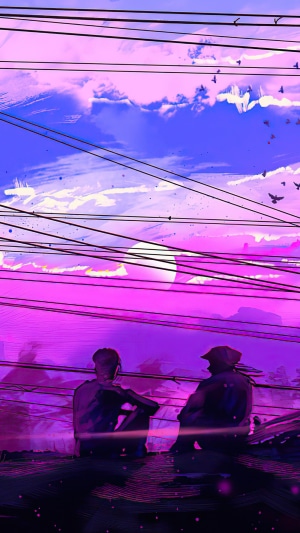 Two people sitting on a rooftop at sunset