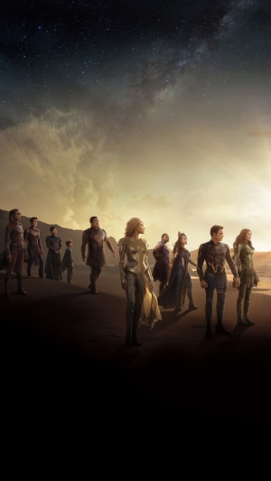 The Eternals standing on a beach at sunset