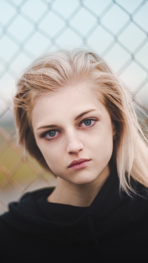 Blonde girl with blue eyes in black hoodie