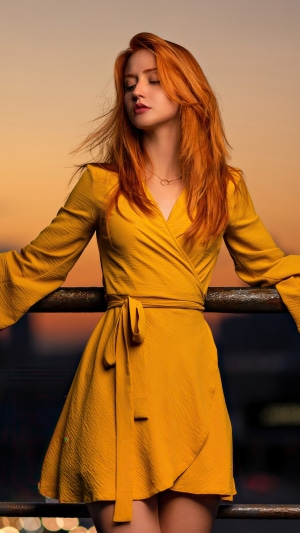 Redhead woman in yellow dress at sunset