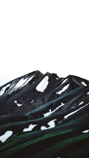 Mountain range with snow patches and green slopes