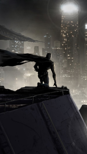 Batman kneeling on a rooftop overlooking a city