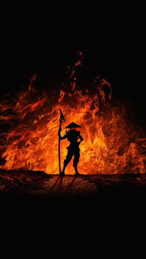 Silhouette of a warrior with a spear in front of flames