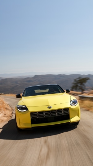 Yellow 2023 Nissan Z driving on a mountain road