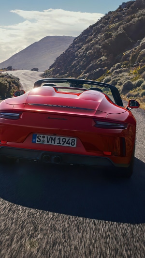 Red Porsche 911 Speedster driving on a mountain road