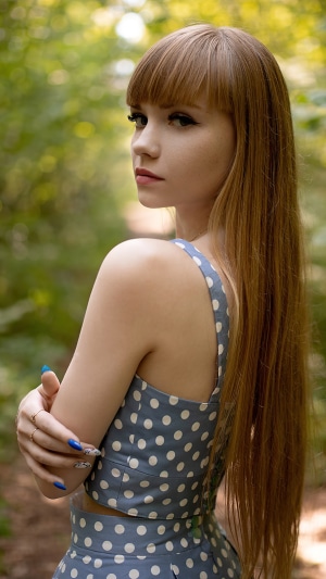Young woman with long blonde hair in a polka dot top