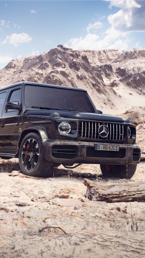 Black Mercedes-Benz G-Class SUV in a rocky desert landscape