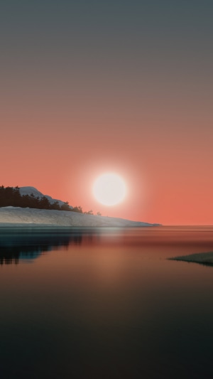 Sunset over a calm lake with snow-capped mountains