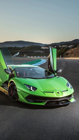 Green Lamborghini Aventador SVJ on a race track