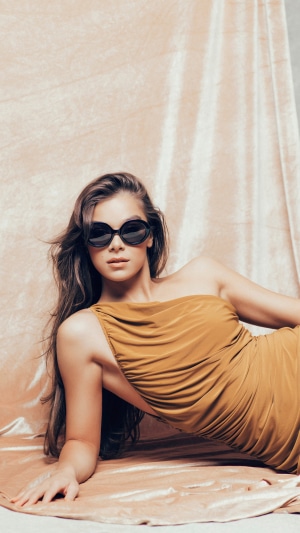 Hailee Steinfeld in a gold dress and sunglasses