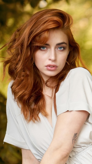 Redhead woman in a white dress outdoors