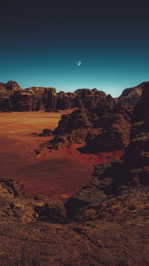 Crescent moon over rocky desert landscape 4K