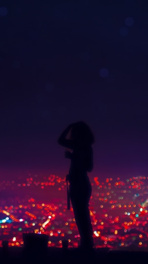 Silhouette of a person overlooking city lights at night