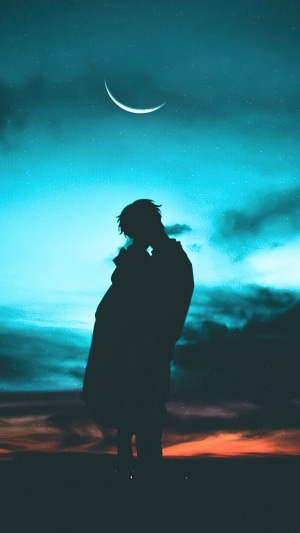 Silhouette of a person under a crescent moon