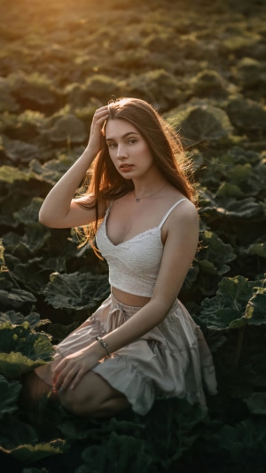 Model in a white top and skirt in a field