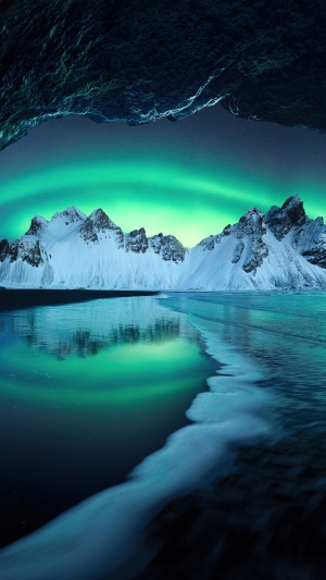 Aurora over snowy mountains in Iceland 4K