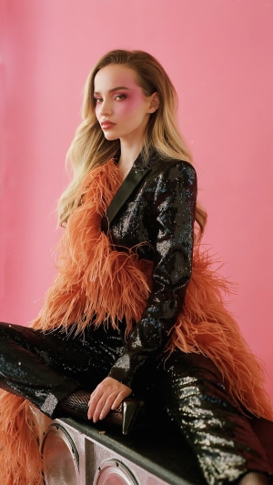 Dove Cameron in a sequined outfit with feather boa
