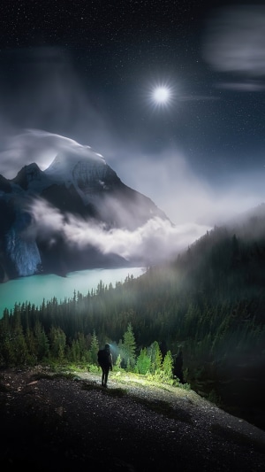 Man with headlamp in mountains at night