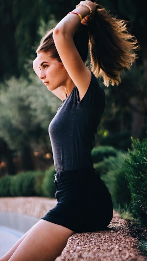 Model tying her hair up outdoors