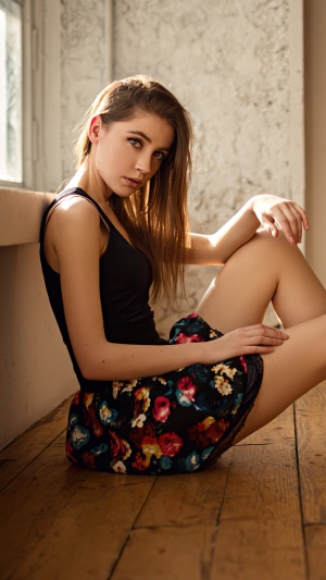 Young woman in black top and floral skirt