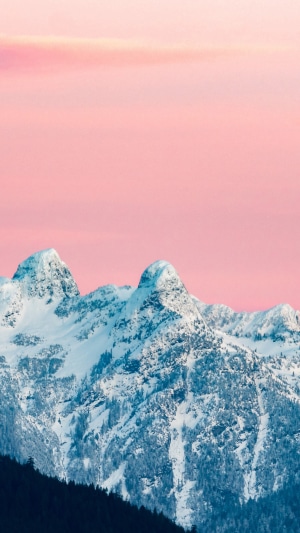 Snow-covered mountains under a pink sky