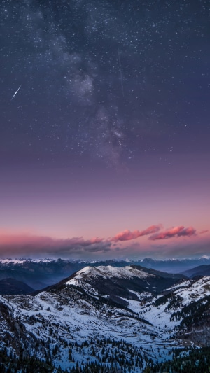 Milky Way over snow-covered mountains at dusk