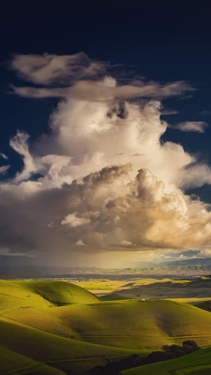 Rolling green hills under dramatic clouds