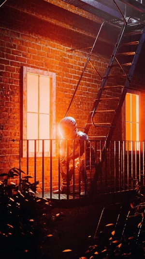 Astronaut on a fire escape at night