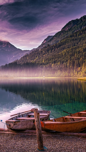 Boats on a misty mountain lake in autumn