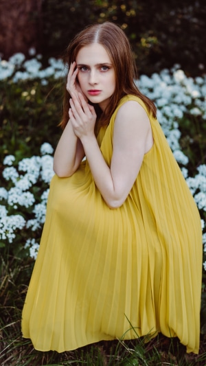 Model in yellow dress among white flowers