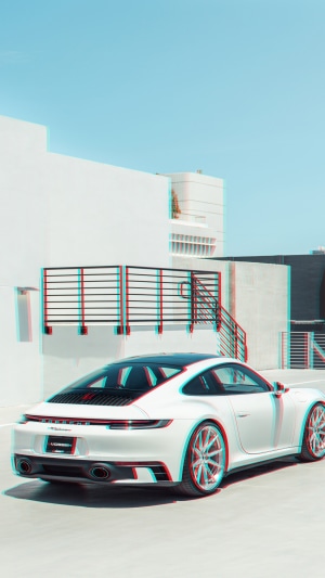 White Porsche 911 parked near a modern building