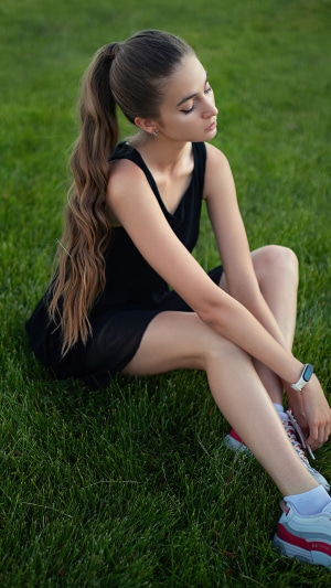 Girl with long hair sitting on grass
