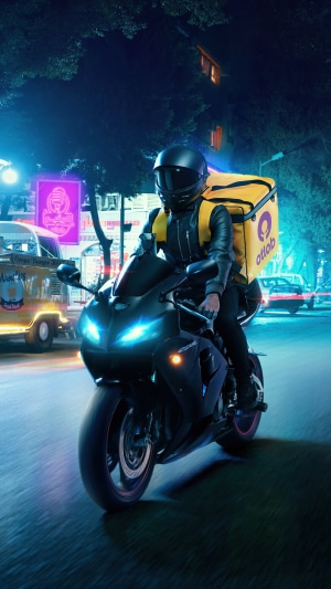 Delivery person on a motorcycle at night