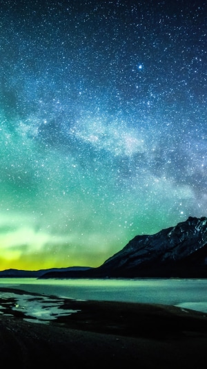 Aurora Borealis over a lake and mountains