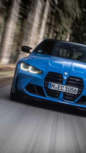 Blue BMW M4 driving on a road