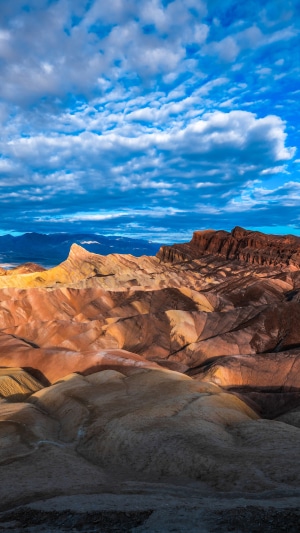 Badlands landscape with colorful rock formations and clouds