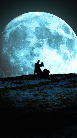 Couple dancing under a large blue moon